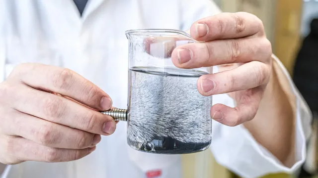 Fionn Ferreira performing his microplastic removal method in a beaker of contaminated water for the European Patent Office.