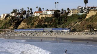 An Amtrak Pacific Surfliner train passes San Clemente Beach in California.