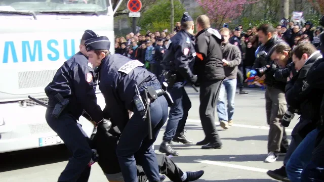 Police encounter a protester during the Olympic torch relay through Paris