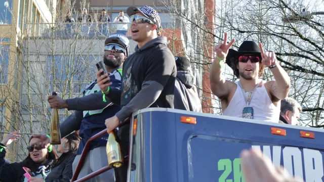 Several Seattle Seahawks players during the Super Bowl LX victory parade, as seen from Denny Way.