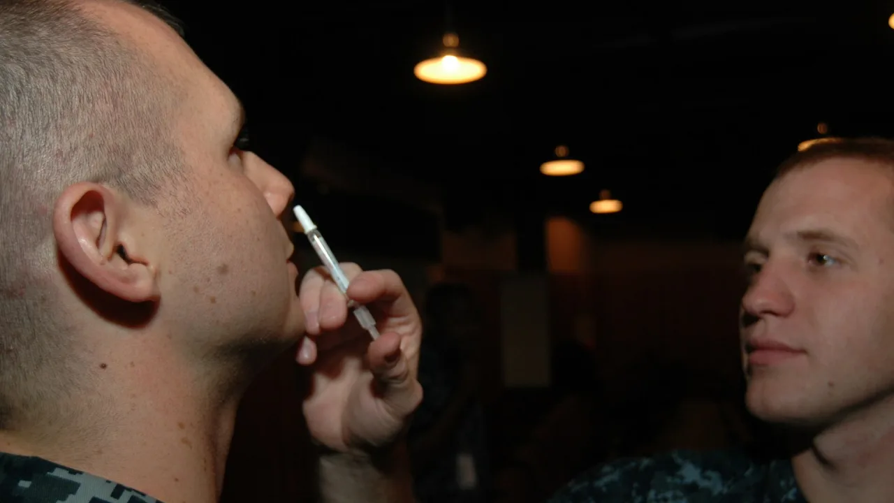 US Navy 110907-N-KE148-015 Hospital Corpsman Christopher Bradburry administers an influenza vaccine via nasal injection to H…