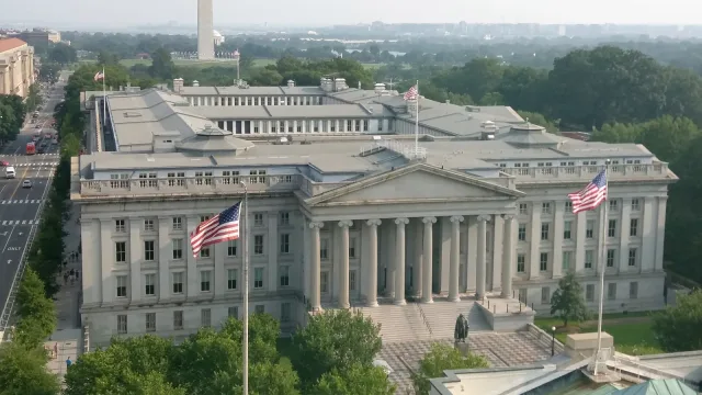 Photograph of the US Treasury building in Washington, DC. Washington Monument in the background.
